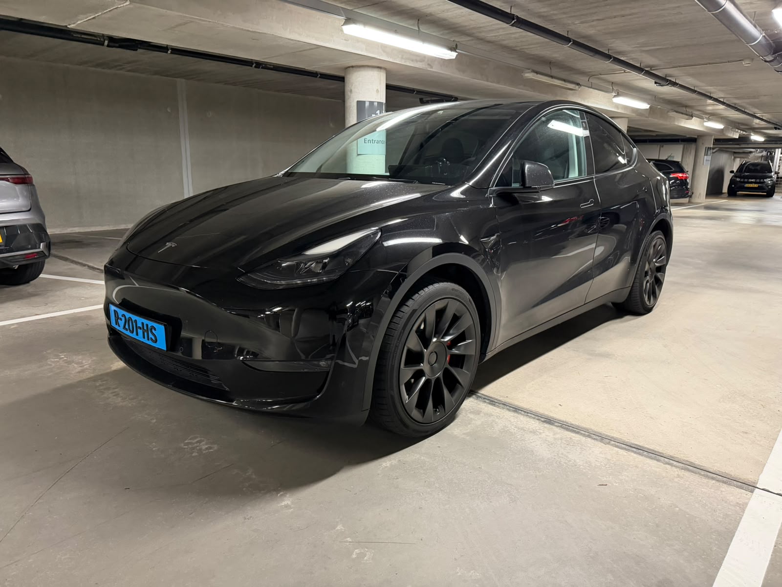Zwarte Tesla Model Y Long Range AWD — linksvoor
